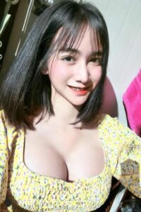 KL Escort Girl Smiling Asian woman in a yellow floral top with black hair. Malaysia Sex Service