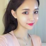 KL Escort Girl Portrait of a smiling Asian woman with dark hair and bright red lipstick. Malaysia Sex Service