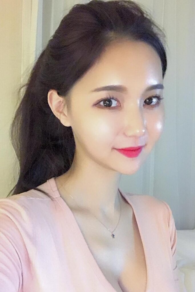 KL Escort Girl Portrait of a smiling Asian woman with dark hair and bright red lipstick. Malaysia Sex Service