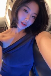 KL Escort Girl Stylish Asian woman with a bob haircut in a blue one-shoulder top. Malaysia Sex Service