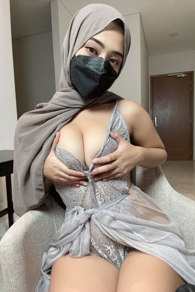 KL Escort Girl Woman in red lace top at event, bathed in red light. Malaysia Sex Service