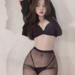 KL Escort Girl Woman in black bra, fishnet tights, and jacket posing. Fashion-forward look. Malaysia Sex Service