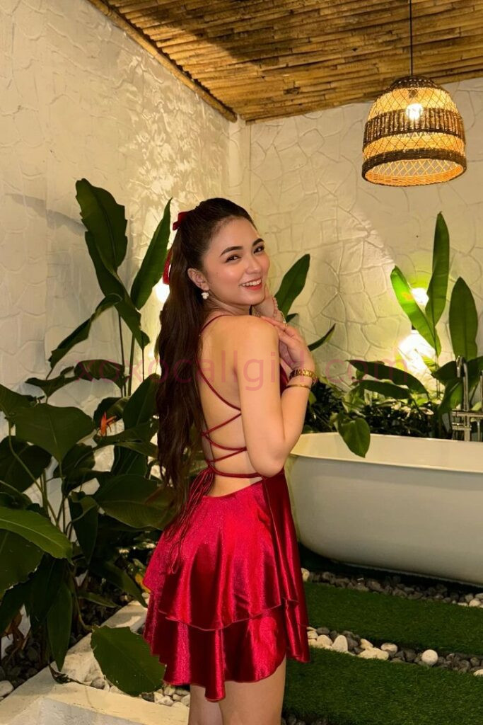 KL Escort Girl Malay Escort in Kuala Lumpur wearing a red dress, smiling and looking back. Malaysia Sex Service