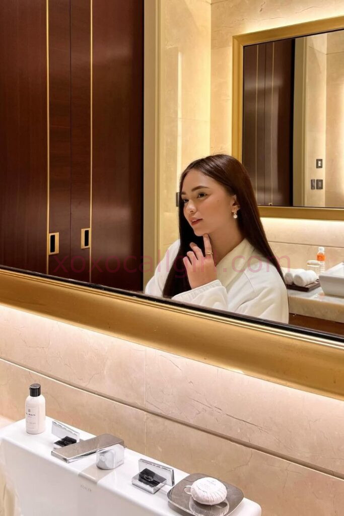 KL Escort Girl Elegant woman in a robe reflected in a bathroom mirror. Malay Escort Kuala Lumpur Malaysia Sex Service