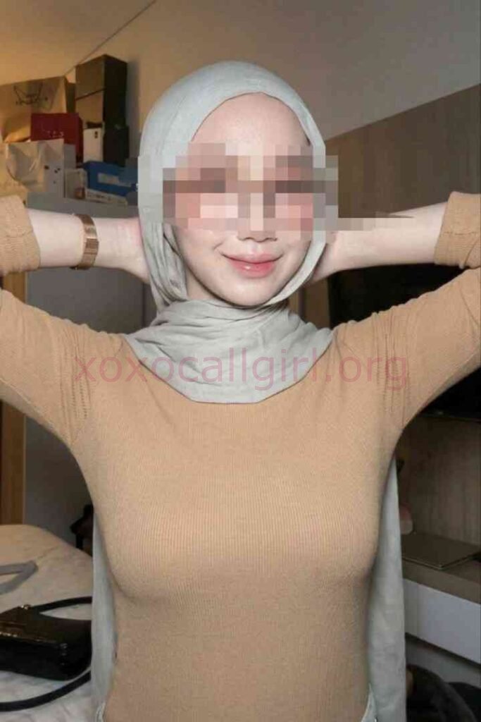KL Escort Girl Woman in hijab and tan top smiling with hands behind head Malaysia Sex Service